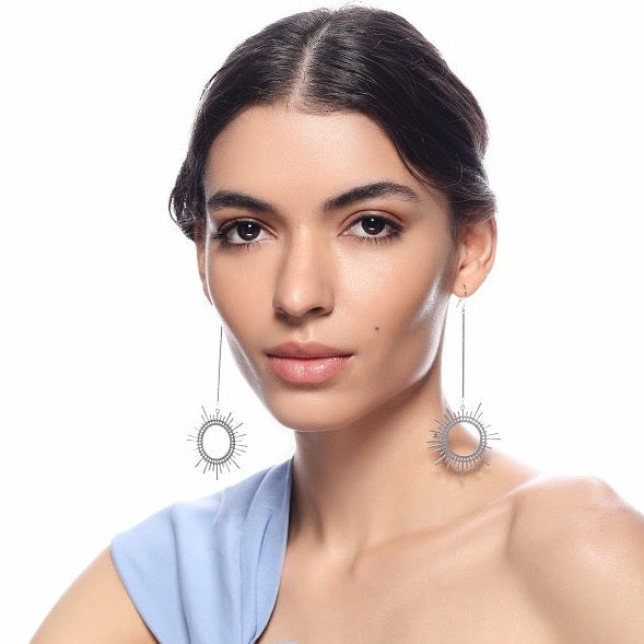 Silver Sun Dangler Earrings by FASHKA, worn by the model.