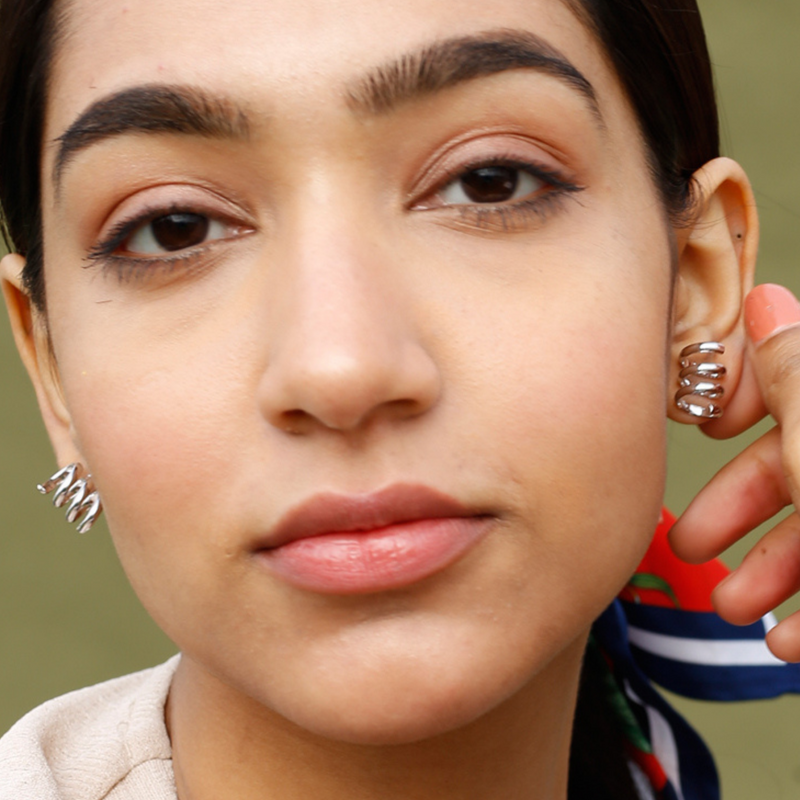 Silver Spirals Stud Earrings by FASHKA, model front pose.