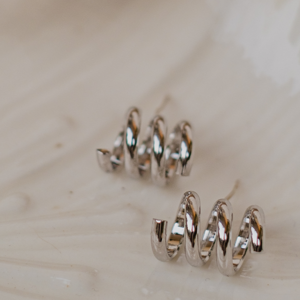 Silver Spirals Stud Earrings by FASHKA, product photo shoot photo.